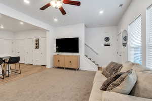 Living room with light colored carpet, recessed lighting, stairs, and ceiling fan