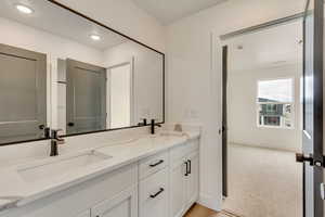 Bathroom featuring baseboards, a sink, recessed lighting, and double vanity