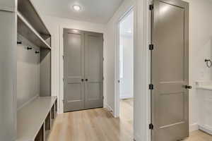 Mudroom with light wood finished floors, baseboards, and recessed lighting