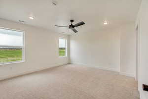 Spare room featuring light carpet, visible vents, recessed lighting, baseboards, and a ceiling fan