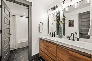 Bathroom featuring tile patterned floors, a sink, double vanity, and shower / tub combo with curtain