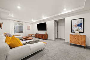 Living Room featuring baseboards, light colored carpet, recessed lighting, and a raised ceiling