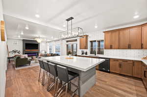 Kitchen featuring open floor plan, a breakfast bar, a sink, dishwasher, and cabinets.