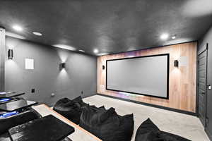 Carpeted cinema with baseboards, recessed lighting, and a textured ceiling