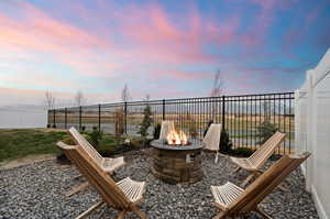 View of patio with fence and an outdoor fire pit