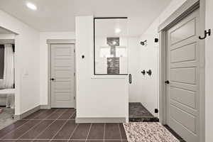 Ensuite bathroom with a shower stall, baseboards, connected bathroom, and tile patterned flooring