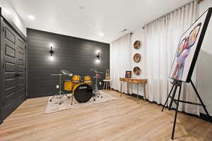 Bedroom featuring wood walls, baseboards, wood finished floors, and recessed lighting