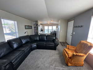 Carpeted living room featuring vaulted ceiling and a textured ceiling