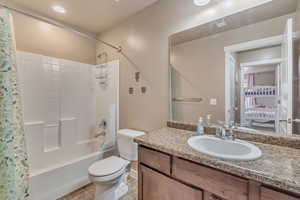 Full bath featuring toilet, vanity, tile patterned flooring, and shower / tub combo with curtain