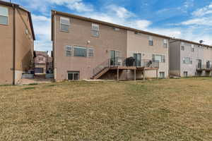 Back of property featuring central air condition unit, stucco siding, a yard, and stairs