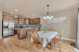 Dining area featuring baseboards, recessed lighting, a notable chandelier, and light wood finished floors