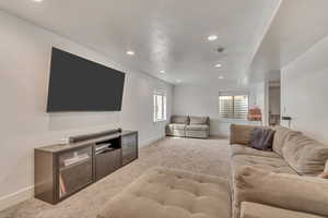 Carpeted living area featuring baseboards and recessed lighting