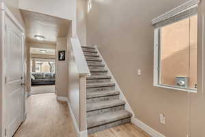 Stairs with baseboards and wood finished floors