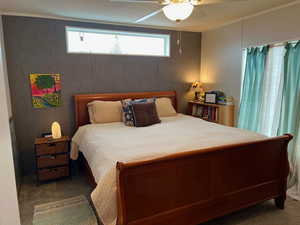 Master bedroom with transom window and ceiling fan. King size bed shown.