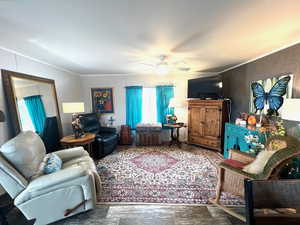 Living room with crown molding and ceiling fan.
