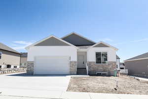 View of front of property with concrete driveway, an attached garage, stone siding, and entry steps