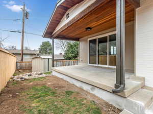 Wooden terrace with an outdoor structure, a fenced backyard, a shed, and a patio