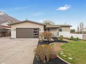 Single story home with a garage, fence, concrete driveway, and a front yard