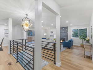 Interior space featuring wood finished floors, an upstairs landing, baseboards, and visible vents