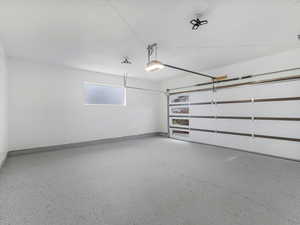 Garage featuring baseboards and a garage door opener