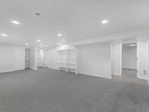 Finished basement featuring baseboards, visible vents, carpet, and recessed lighting