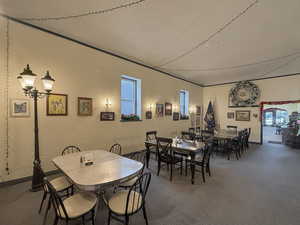 Dining room featuring carpet, a textured wall, and a textured ceiling