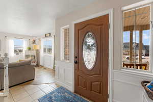 Entrance foyer featuring light tile patterned flooring and a textured ceiling