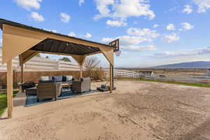 View of patio / terrace with an outdoor living space, a gazebo, fence, and a mountain view