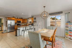 Dining area featuring light tile patterned floors, a notable chandelier, and recessed lighting