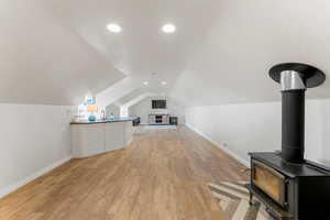 Additional living space featuring baseboards, a textured ceiling, visible vents, and light wood-style floors