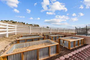 View of yard with fence, a rural view, and a trampoline
