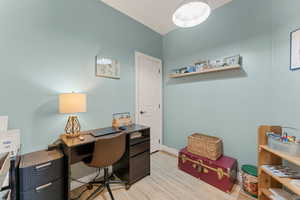 Office area featuring light wood-style flooring and baseboards