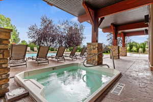 Pool with a patio area and an outdoor hot tub