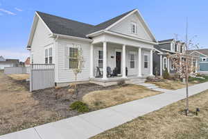 Neoclassical / greek revival house featuring covered porch and roof with shingles