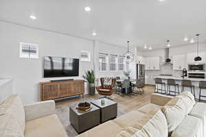 Living area with light wood-style flooring, a chandelier, and recessed lighting