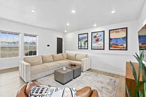 Living area with baseboards, light wood-type flooring, and recessed lighting