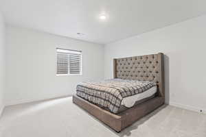 Bedroom featuring baseboards, visible vents, and light colored carpet