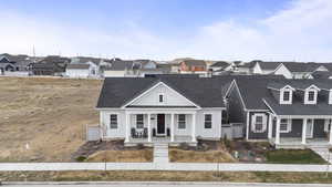 View of front of property with fence, a residential view, a porch, and roof with shingles