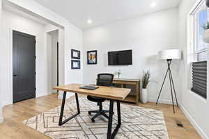 Home office featuring recessed lighting, baseboards, light wood-style floors, and visible vents