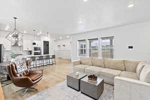Living room featuring visible vents, recessed lighting, and light wood finished floors