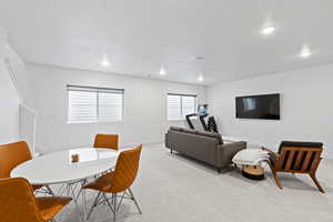 Dining room with light colored carpet, recessed lighting, baseboards, and a textured ceiling