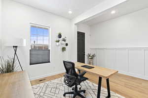 Office space featuring a wainscoted wall, a decorative wall, visible vents, wood finished floors, and recessed lighting
