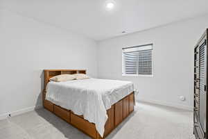 Bedroom featuring light carpet, a textured ceiling, baseboards, and visible vents