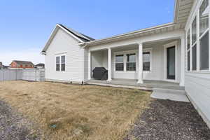 Exterior space featuring covered porch, a yard, fence, and roof mounted solar panels