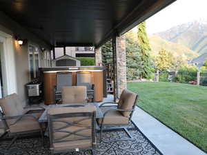 View of patio with outdoor dining space, fence, and a mountain view