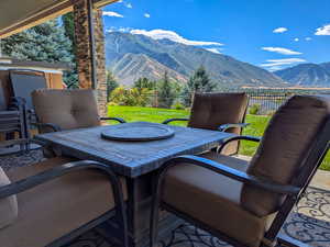 View of patio with outdoor dining space, fence, and a mountain view