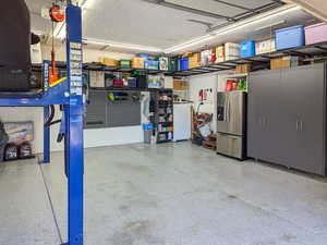 Two Car garage with car lift, extra width and depth.  Storage alongside walls and overhead.