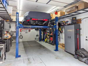 Single car garage with car lift, extra width and depth. Storage alongside walls and overhead.