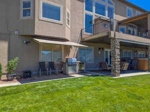 Back of property, backyard, and a patio, deck, and covered grilling area.