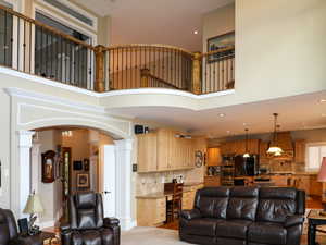 Living area featuring recessed lighting, arched walkways, baseboards, and ornate columns